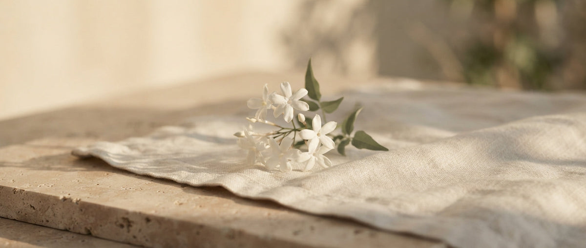 Jasminzweig auf gefaltetem Leinen – Signature Scent finden